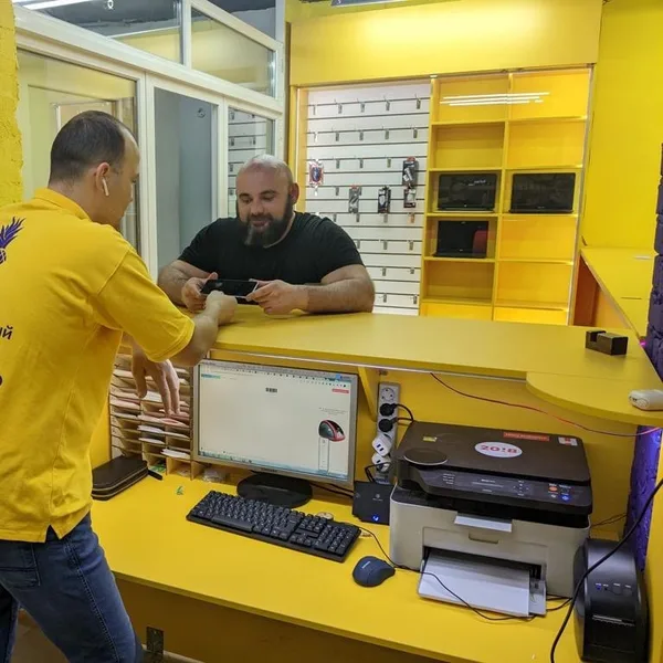 Приёмщик сервисного центра Паскаль принимает телефон у клиента на Плехановской